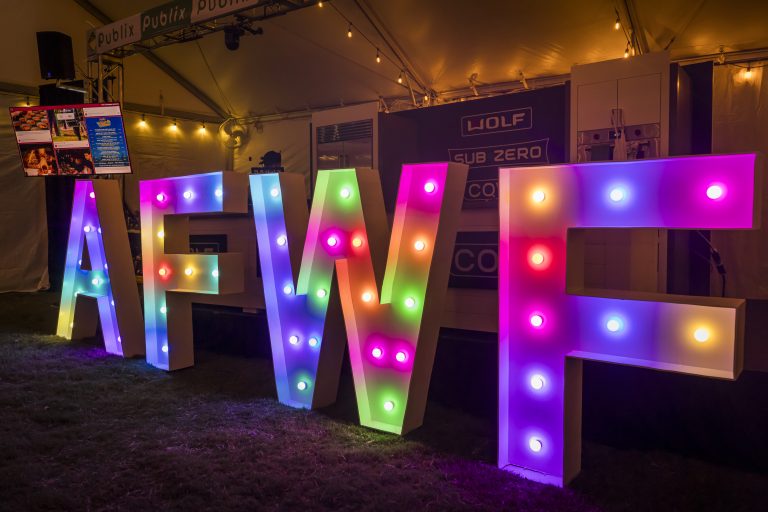 The Atlanta Food & Wine Festival, presented by Invesco QQQ, attracts food and drink lovers from across the country. Returning for its 14th year, this multi-day celebration of Southern cuisine, beverages, and culture brings together award-winning chefs, mixologists, farmers, and culinary artisans from 13 different states. I've had a chance to attend the Atlanta Food & Wine Festival for years, and here are more details on why you should attend. With the "States of Motion" theme for 2025, the festival will highlight how food connects people across regions, generations, and cultures through movement, storytelling, and tradition. Expect an expanded lineup of immersive experiences, tasting tents, intimate chef collaborations, and engaging cooking demonstrations. This year’s festival will showcase more than 200 of the South’s most celebrated chefs. Featured names include Andrew Zimmern, Scott Conant, Rodney Scott, Charmain Ware-Jason, Joshua Wetshtein of Tiny Lou’s, Gizzy Rawlins of Ela, Howard and Anita Hsu of Sweet Auburn Barbecue, Wil Drake of HERO Doughnuts, and Josue Pena of The Iberian Pig, among many others. 2025 Atlanta Food & Wine Festival Dates The 2025 Atlanta Food & Wine Festival takes place September 11–14, 2025, at Historic Fourth Ward Park in Atlanta, GA. This year introduces an extra day of tasting tents. Credit Raftermen Photography How to Get to the Atlanta Food & Wine Festival  If traveling to Atlanta by plane, fly into Hartsfield-Jackson Atlanta International Airport (ATL). Rideshare: Apps like Uber and Lyft are widely used in Atlanta, making it easy to get to and from the festival. It's better to rideshare versus parking at the festival. Where is the Atlanta Food & Wine Festival Located? The Atlanta Food & Wine Festival's main event is held at Historic Fourth Ward Park, 680 Dallas Street NE, Atlanta, GA 30308, while curated events and chef collaborations are held at multiple venues across Atlanta. Atlanta Food & Wine Festival Events Tasting Tents Tasting Tents, located at Historic Fourth Ward Park with the entrance across from Ponce City Market, the Tasting Tents are the festival's main event, featuring over 60 tasting stations from local restaurants, mixologists, and more. Each ticket includes unlimited food, free-flowing drinks, and live entertainment. VIP tickets include an hour-early entrance. For tickets to the festival, click here.  AFWF Tasting Tents, Credit Raftermen Photography Whiskey & Fire Atlanta New for 2025, Whiskey & Fire Atlanta debuts as part of the Atlanta Food & Wine Festival. This dynamic walk-around tasting event featuring live-fire cooking and global whiskey pairings takes place on Saturday, September 13th, at Guardian Works, located at 775 Echo Street NW, Atlanta, GA 30318 Hosted by culinary personality Andrew Zimmern, the experience invites guests to roam between open-fire stations where Atlanta’s top chefs compete with bold, smoky creations, perfectly matched with curated whiskey selections. Two ticket options are available: VIP Admission (12:00 PM – 3:30 PM): Includes early access for exclusive pours along with all general admission offerings. General Admission (12:45 PM – 3:30 PM): Features unlimited tastings, whiskey pours, and a keepsake tasting glass. Purchase Whiskey & Fire Atlanta Tickets Publix Culinary Demonstration Stage Hands-on demos with live Q&A. Lineup & times Thu, Sept 11, 7:45–8:30 pm: Chefs Kevin Belton & Eleazar Fuerte (Mike’s Amazing) Thu, Sept 11, 8:45–9:30 pm: Chef Nicola Blaque (Visit San Antonio) Fri, Sept 12, 7:45–8:30 pm: Andrew Zimmern Sat, Sept 13, 7:45–8:30 pm: Chef Fernando Desa (Goya Foods) Where to stay for the 2025 Atlanta Food & Wine Festival Finding the right place to stay during the festival is essential to making the most of your weekend. Here are some nearby hotel options: The Starling Atlanta 188 14th St NE, Atlanta, Georgia 30361 This stylish hotel is located in the heart of Midtown, offering modern amenities and a convenient location close to the festival's main events. See current reviews and prices of The Starling Hotel in Atlanta Wylie Hotel 551 Ponce De Leon Ave NE, Atlanta, Georgia 30308 A charming boutique hotel with a historic feel, Wylie Hotel is located near the festival's tasting tents and offers a unique, intimate experience. See reviews and current prices of Wylie Hotel Loews Atlanta Hotel 1065 Peachtree Street NE, Atlanta, Georgia 30309 A luxurious option in Midtown, Loews Atlanta Hotel provides upscale accommodations and is within walking distance of many festival events. See current reviews and prices of Loews Atlanta Hotel See my personal Review of Loews Atlanta Hotel Canopy By Hilton Atlanta 1414 West Peachtree Street, Atlanta, Georgia 30309 This modern hotel offers a comfortable stay and easy access to the festival's activities and Atlanta's vibrant Midtown neighborhood. See reviews and current prices of Canopy By Hilton Atlanta Atlanta Food & Wine Festival Tips To make the most of your festival experience, here are a few tips to keep in mind: Purchase Tickets Early/Plan Ahead: Secure your tickets as soon as possible since they can sell out quickly. Consider buying weekend passes that give you access to multiple days. Review the themes for each day and decide which tents and flavors you're most excited about. If you want to attend a particular chef or demonstration, mark it on your schedule. Stay Hydrated: September in Atlanta can be warm and humid, so drink plenty of water throughout the day.  Dress Comfortably: The festival involves a lot of walking and standing, so wear comfortable shoes and lightweight clothing. For the outdoor events, remember to bring sunscreen and a hat. Explore Beyond the Festival: Atlanta is a vibrant city with plenty to offer beyond the Food & Wine Festival. Consider exploring local attractions like the Atlanta BeltLine, Piedmont Park, and Ponce City Market during your stay. The South’s defining festival of food & drink culture. Each year, I've tasted great food and drinks. The music and fun activations make the experience unmatched. Be sure to get your Atlanta Food & Wine Festival tickets today!