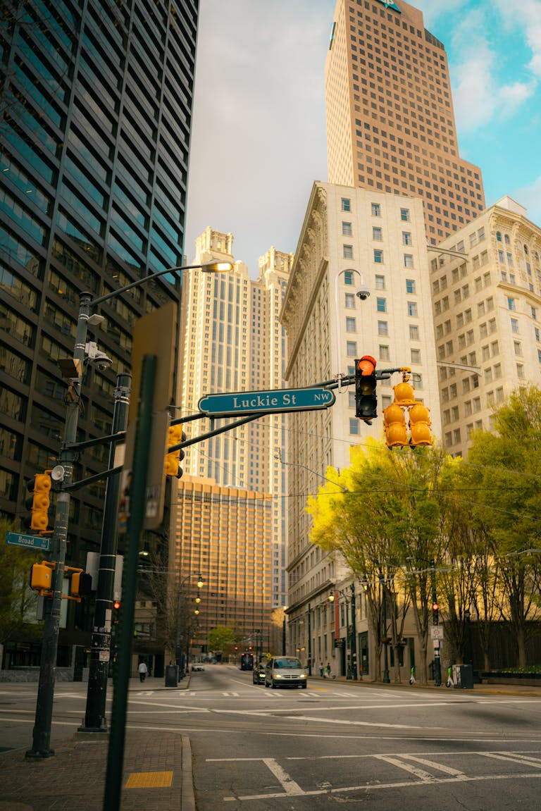 Urban street view with towering buildings and traffic lights at dusk.