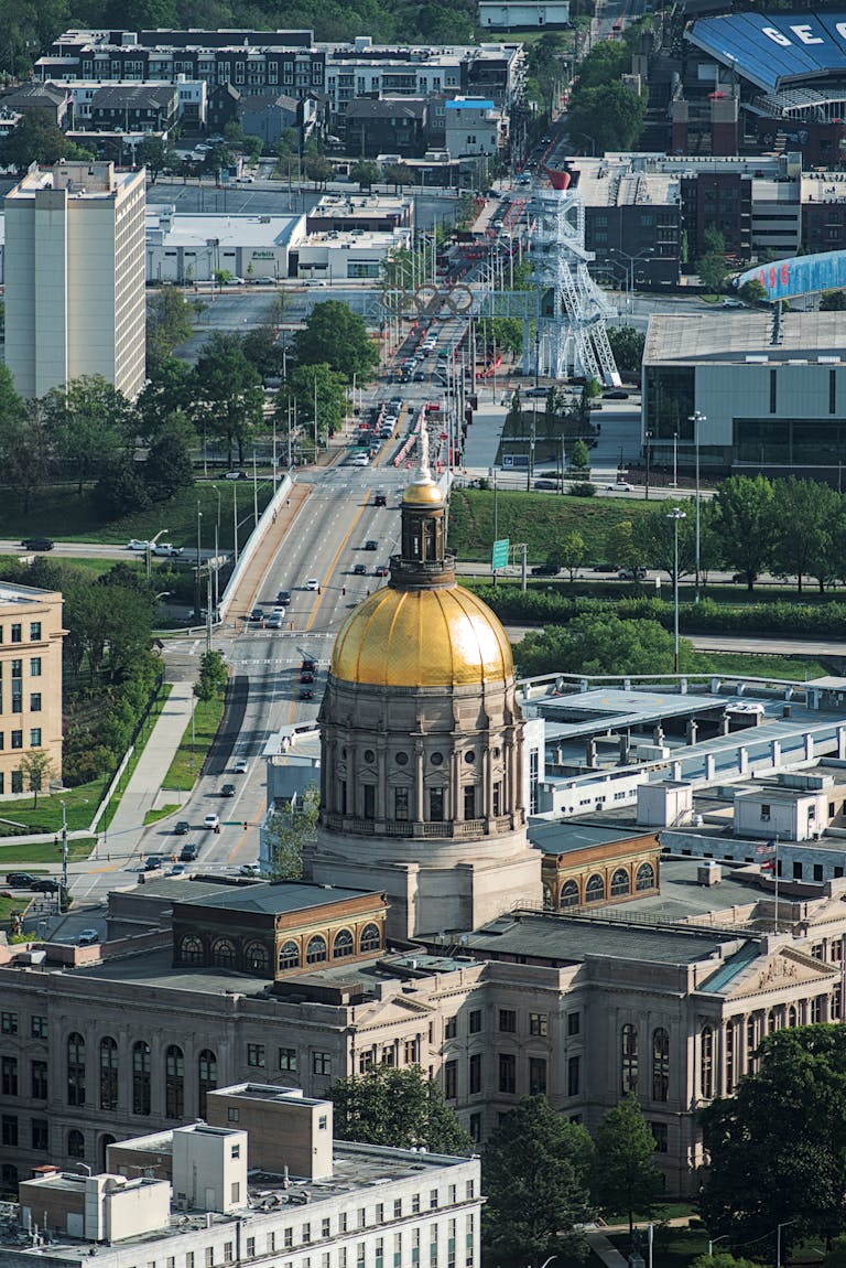 Aerial view showcasing the golden dome of the Georgia State Capitol amidst Atlanta's urban landscape.