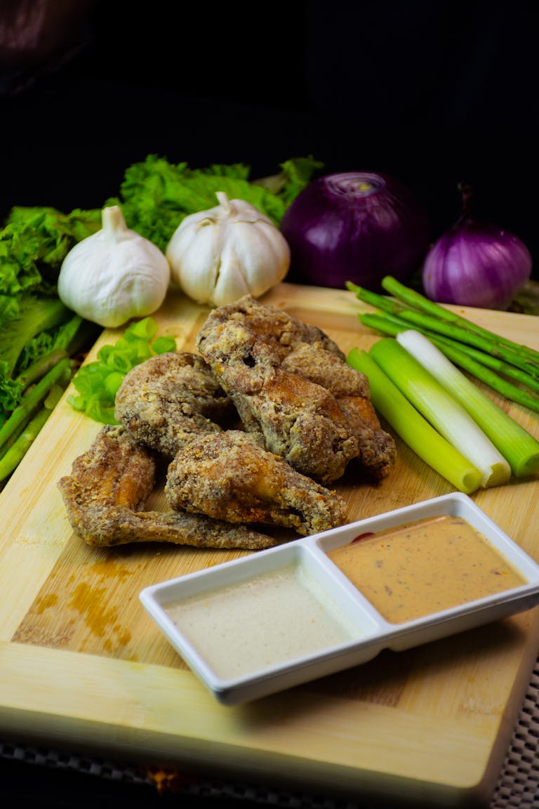 Crispy fried chicken wings with garlic and onions, served with dipping sauces.