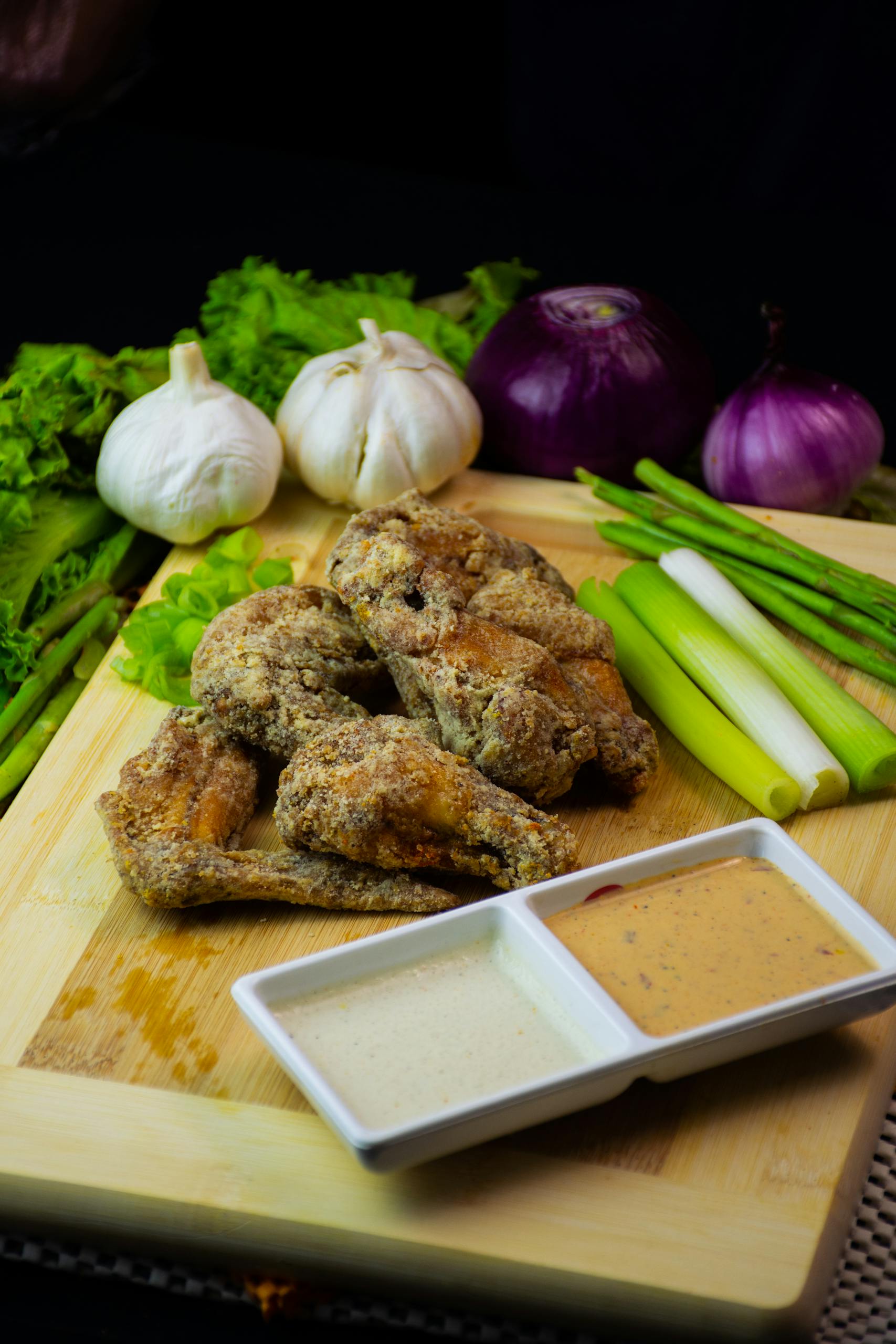 Crispy fried chicken wings with garlic and onions, served with dipping sauces.