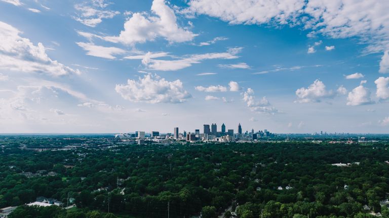 Stunning aerial view of Atlanta's skyline with lush greenery under a vibrant blue sky.